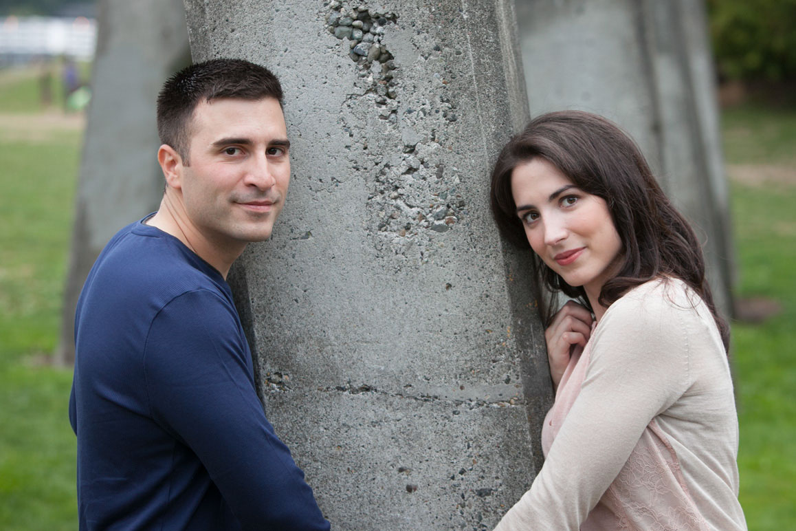 Engagement photo sesion at Gasworks Park Couple holding hands in front of concrete arches at Gasworks Park engagement photo session