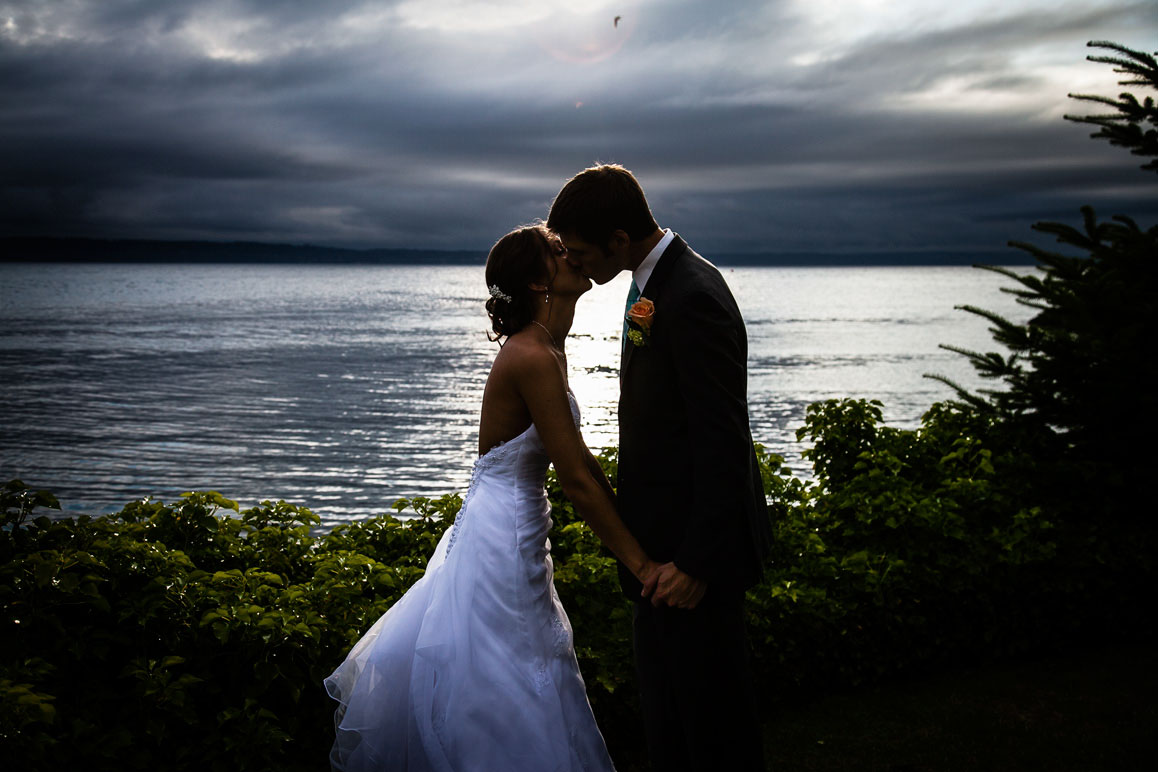 Wedding at Shilshole Bay Beach Club in Seattle Backlit sunset photo of bride and groom kissing at Shilshole Bay Beach Club