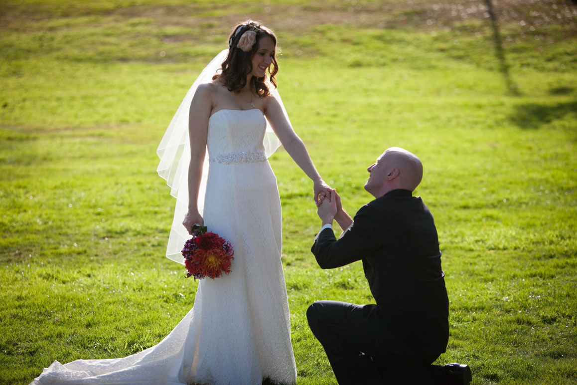 Sarah & Josh - Wedding in West Seattle Groom kneeling in front of bride holding her hand at Hamilton Overlook in Seattle
